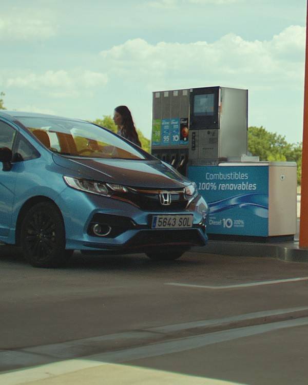 Un coche repostando combustible 100% renovable en una estación de servicio Repsol