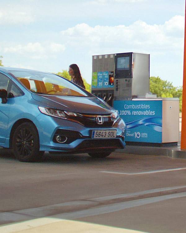 Un coche repostando combustible renovable en una estación de servicio Repsol