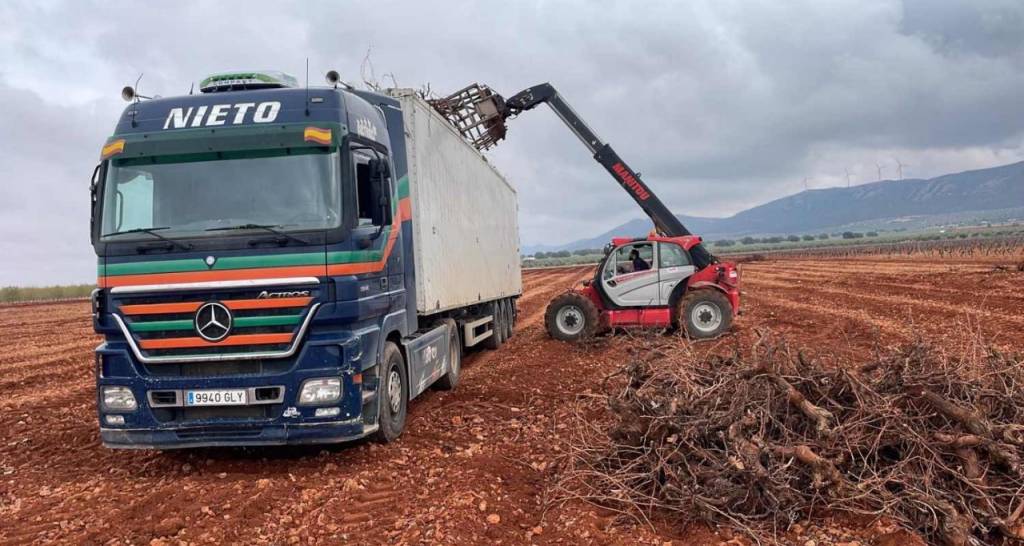 Un camión retirando biomasa en un viñedo